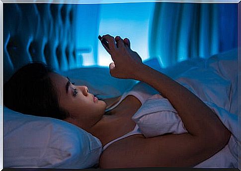 Woman in bed with mobile phone.