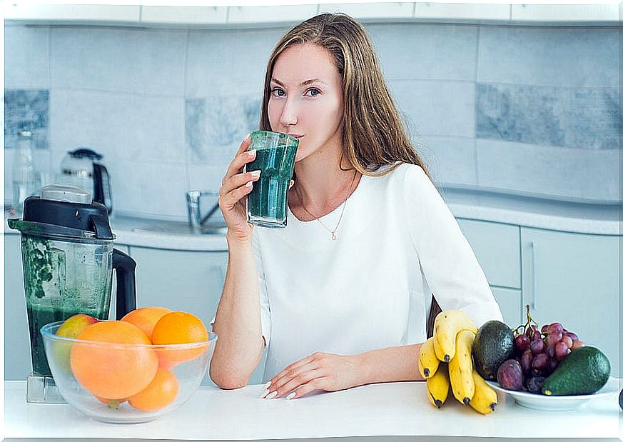 Woman drinking green smoothie as part of a detox plan.