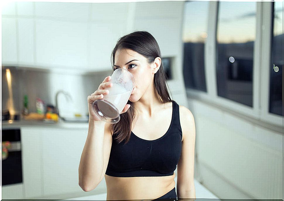 woman drinking a protein shake after exercising